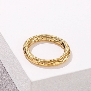 Macro detail of golden stainless steel ring featuring textured diamond quilted pattern