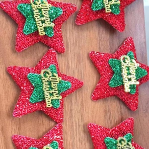 Sparkling red and green star ornaments with Merry Christmas lettering on wood background