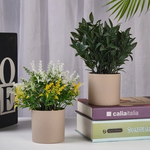 Set of two realistic artificial potted plants in beige ceramic pots for home decor