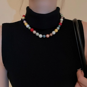 Close-up of colorful pearl necklace worn by a model on a black sleeveless turtleneck