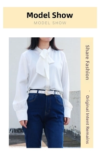 White faux leather belt with metal buckle styled with a bow shirt and denim jeans