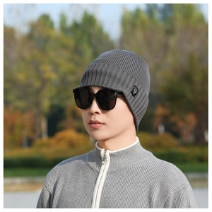 Detail of grey ribbed knit beanie with visor brim showing high-quality wool texture