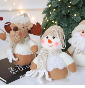 Close-up of plush Christmas snowman, reindeer, and Santa figurines with festive decor