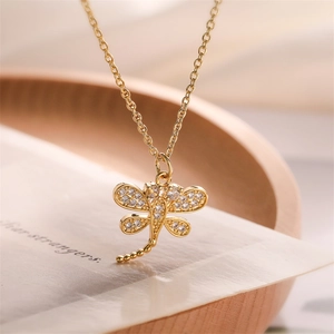 Detailed close-up of a gold dragonfly pendant necklace with sparkling zircon wings