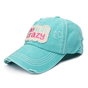 Detail of distressed teal baseball cap with beach crazy embroidery and washed finish