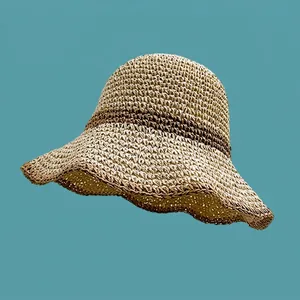 Detail of hand-woven breathable straw bucket hat featuring a brown contrast stripe accent