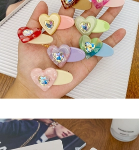 Close-up of heart-shaped candy color acetate hair clips with sparkling rhinestone accents