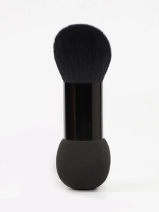Detailed close-up of dual-ended makeup tool with soft black bristles and sponge tip
