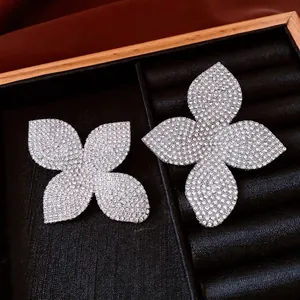 Boucles d'oreilles fleuries élégantes avec diamants pavés sur présentoir en velours