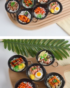 Detailed macro view of miniature Japanese eel bowl keychains on a wooden tray