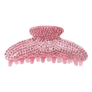 Macro detail of large pink acrylic shark hair claw clip with full rhinestone inlay