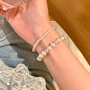 Détail de bracelets en perles multicouches élégants avec perles en strass sur un modèle