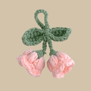 Handmade crochet lily of the valley flower keychain with pink petals and green leaves