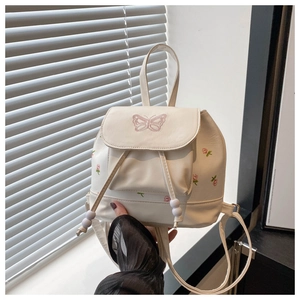 Close-up of white PU leather backpack with butterfly and flower embroidery details