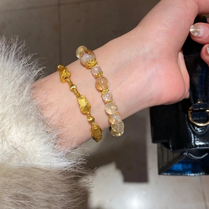 Detail of gold-plated lava texture chain and yellow rutilated quartz beaded bracelet