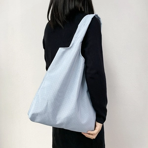 Close-up of the light blue polka dot tote bag showing the fabric texture and shoulder strap
