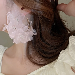 Detail of pink lace flower earrings with pearl accents on a golden C-shaped hoop