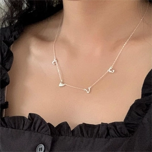 Detail of 925 sterling silver LOVE heart pendant necklace on a person wearing black lace