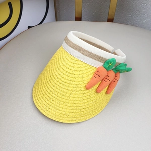 Close-up of a yellow woven sun hat for children featuring three 3D carrot decorations