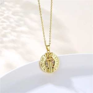 Macro detail of gold cobra coin pendant with colorful zircon stones on white tray
