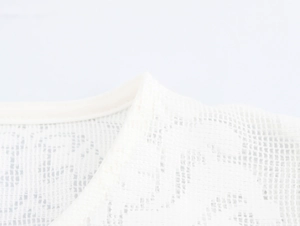 Detailed close-up of white lace neckline showing intricate cut-out patterns and stitching