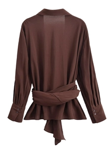 Détail d'une chemise marron foncé à manches longues avec ceinture à la taille
