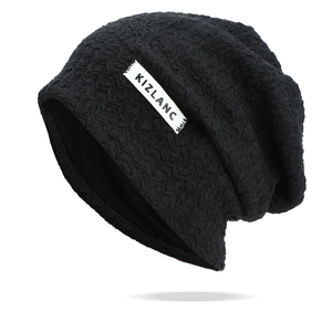 Close-up of black knitted slouchy beanie with wave-pattern texture and white KIZLANC label