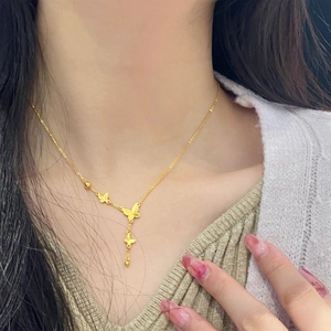 18K gold plated butterfly tassel necklace in titanium steel worn on a woman's neck