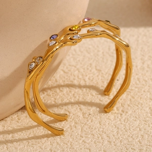 Detail of 18K gold branch cuff bangle featuring vibrant multi-color crystal stones