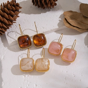 Trois paires de boucles d'oreilles carrées en résine ambre, rose et crème avec bord doré
