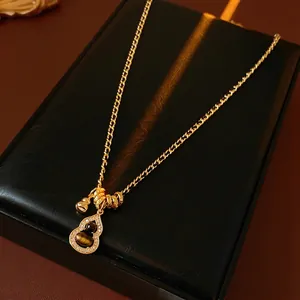 Golden Wu Lou necklace with tiger eye stone and zircons on black leather display