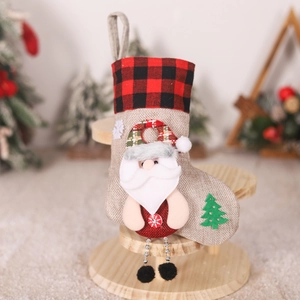 Macro detail of burlap Christmas stocking with 3D Santa and red buffalo plaid cuff