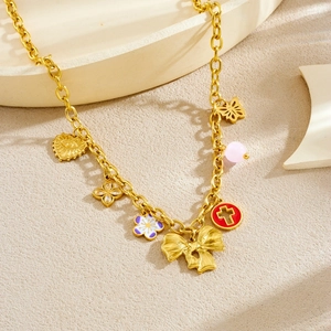 Gold-plated necklace with diverse floral, heart and star charms on textured background