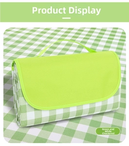 Macro view of portable folded green plaid Oxford picnic mat with reinforced handle detail