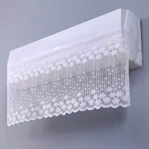 Close-up of white lace air conditioner cover with floral embroidery and wavy edges