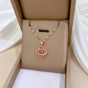 Rose gold dancing four-leaf flower necklace with sparkling cubic zirconia on silk background