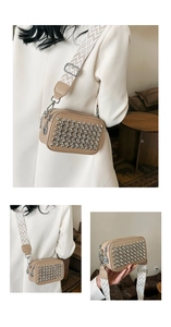 Detail of crossbody camera bag featuring silver rivets and wide geometric patterned strap