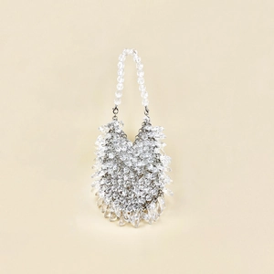 Detail of handmade white beaded handbag with silver metal buckle and crystal texture