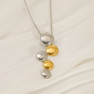 Collier à maillons bicolores argent et or avec zircon incrusté sur tissu blanc