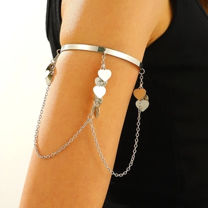 Silver armlet with delicate metal chains and heart pendants on polished open band