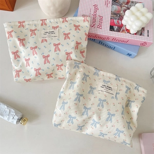 Detalle de neceseres de tela con estampado de lazos y etiqueta tejida decorativa