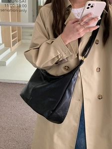 Classic black vintage hobo bag styled with a trench coat for a versatile daily look