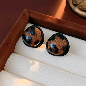 Gros plan de boucles d'oreilles léopard avec cadres dorés irréguliers en boîte à bijoux