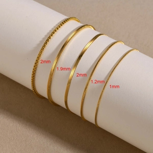 Detail of five gold plated stainless steel chains showing 1mm to 2mm widths and textures