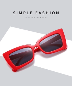 Detail shot of oversized red square sunglasses with a glossy finish and thick fashion frame