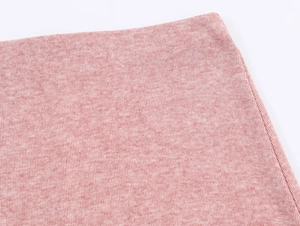 Gros plan sur la texture du tricot rose chiné montrant les détails fins du tissu doux
