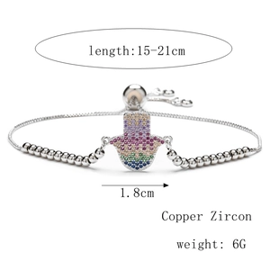 Macro shot of silver-plated copper Hamsa hand bracelet with colorful cubic zirconia