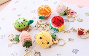 Detailed set of six handmade crochet fruit keychains with colorful bells and golden rings