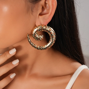 Close-up of a large leopard print spiral earring with high-shine metallic finish
