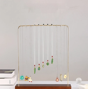 Detail view of wooden base and golden iron hooks showing necklace storage capacity